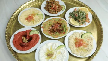 Assorted Middle Eastern appetizers on golden tray.