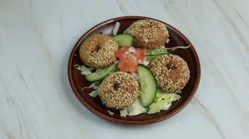 Falafel with salad on brown plate.