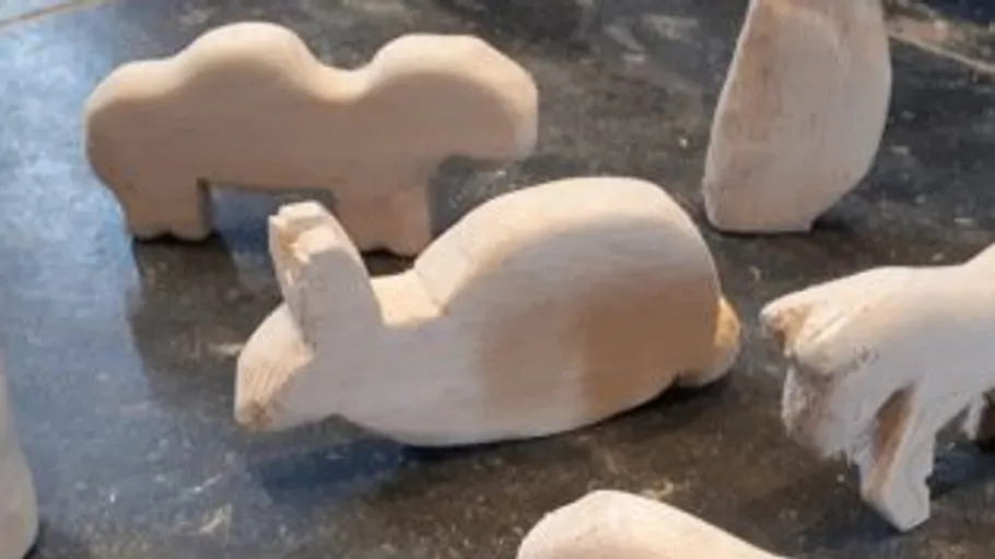 Wooden animal carvings on a dark surface.