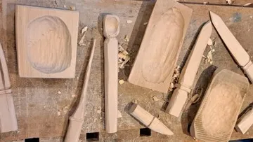 Holzobjekte werden auf Werkbank geschnitzt.