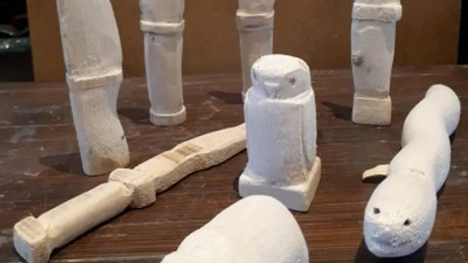 Carved wooden figures on a wooden table.