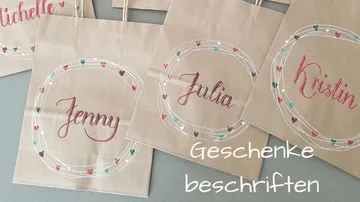 Paper bags with names on gray surface.