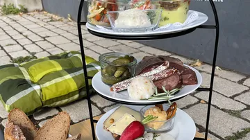 Three-tier stand with food, outdoor setting.