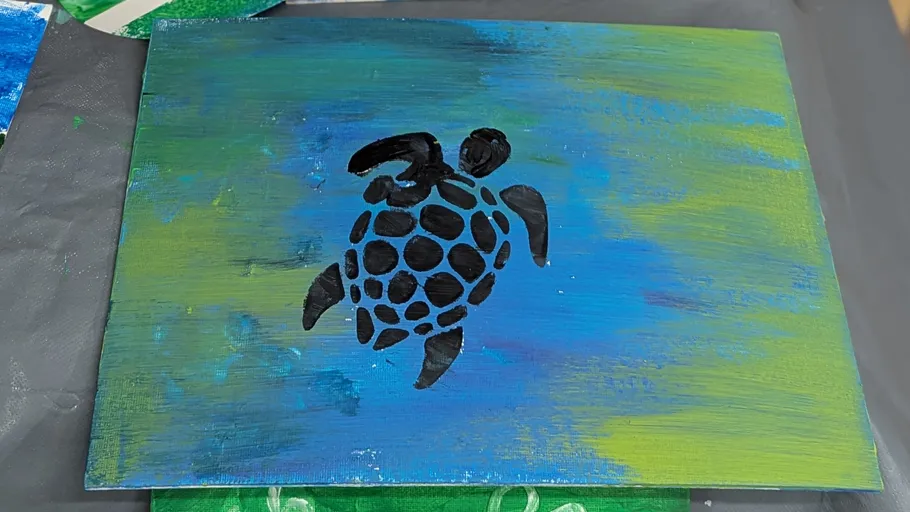 Black turtle painted on blue-green canvas.