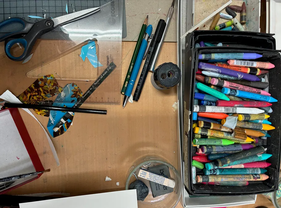 Kunstmaterialien auf einem Holztisch.