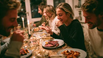 Freunde speisen gemeinsam an gemütlichem Tisch.