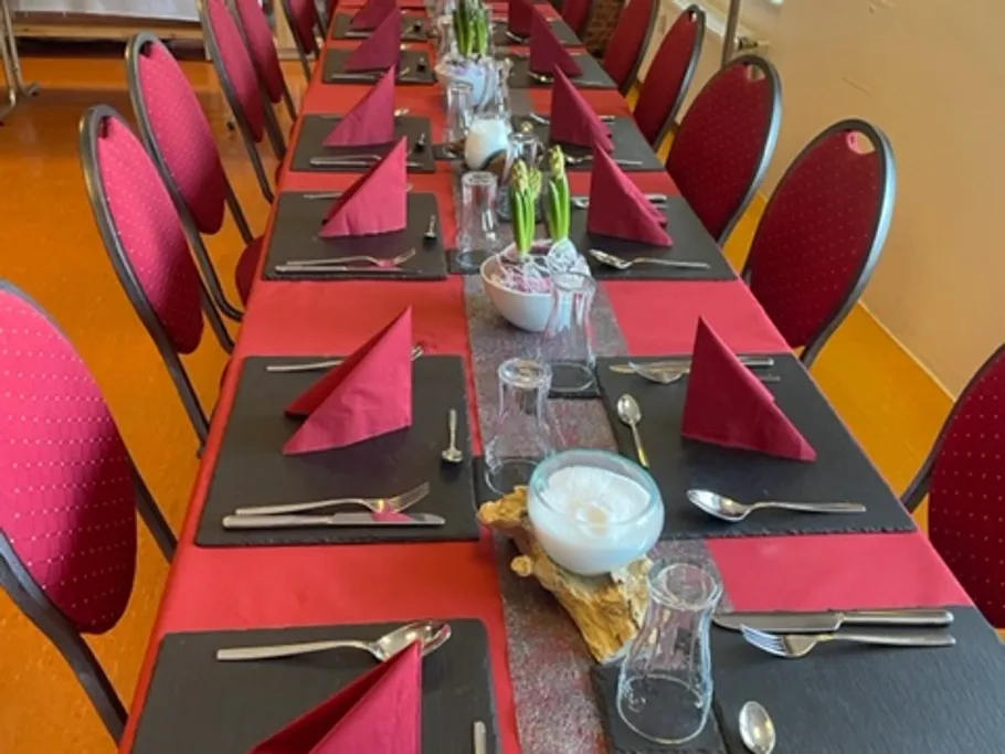 Table covered with red napkins in a festive room.