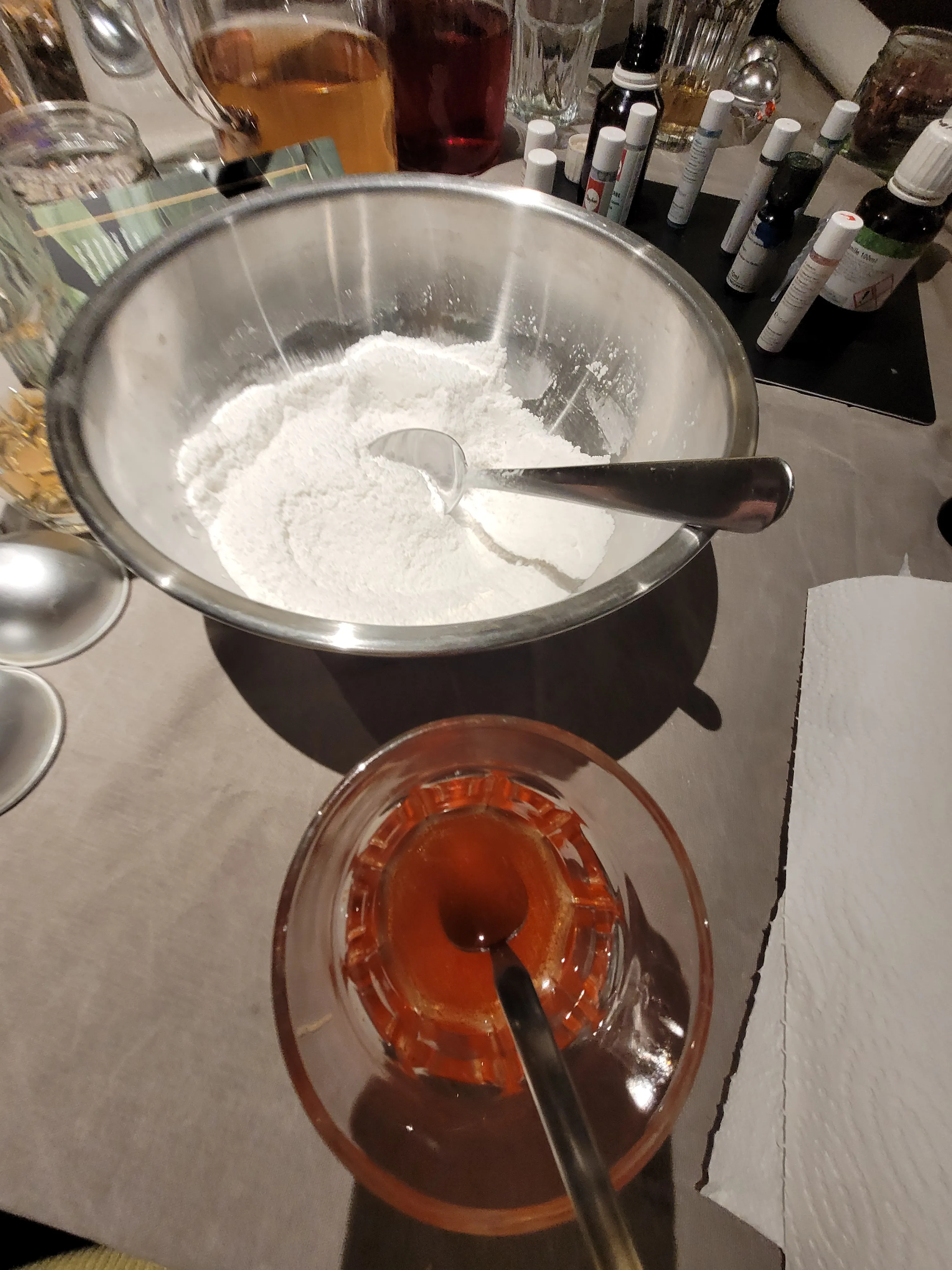 Bowl with powder and glass with liquid on table.