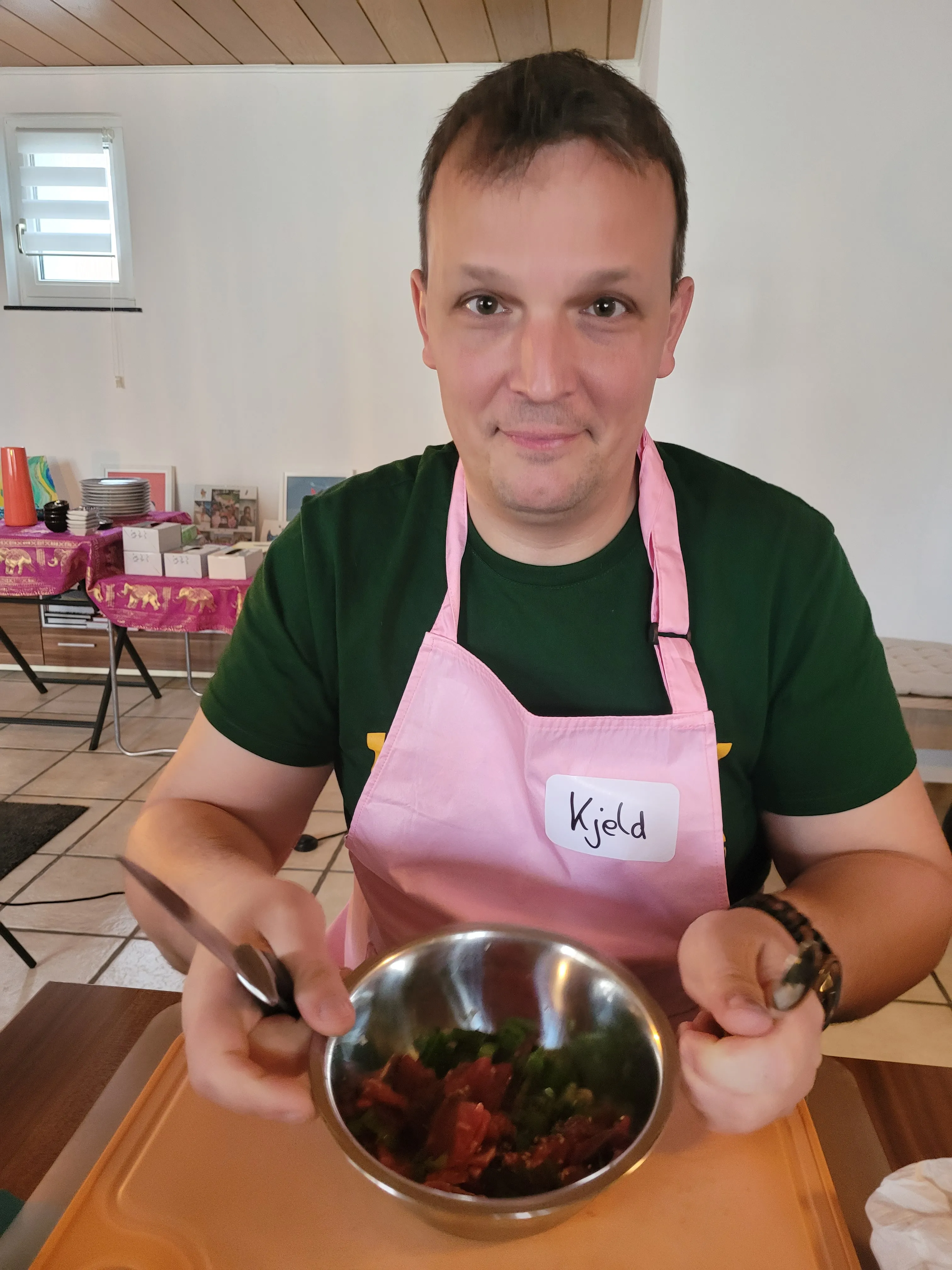 Person holding salad bowl in room.