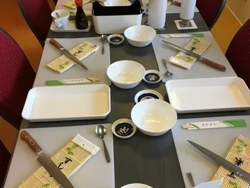 Tisch gedeckt mit Geschirr und Besteck, bereit zum Essen.