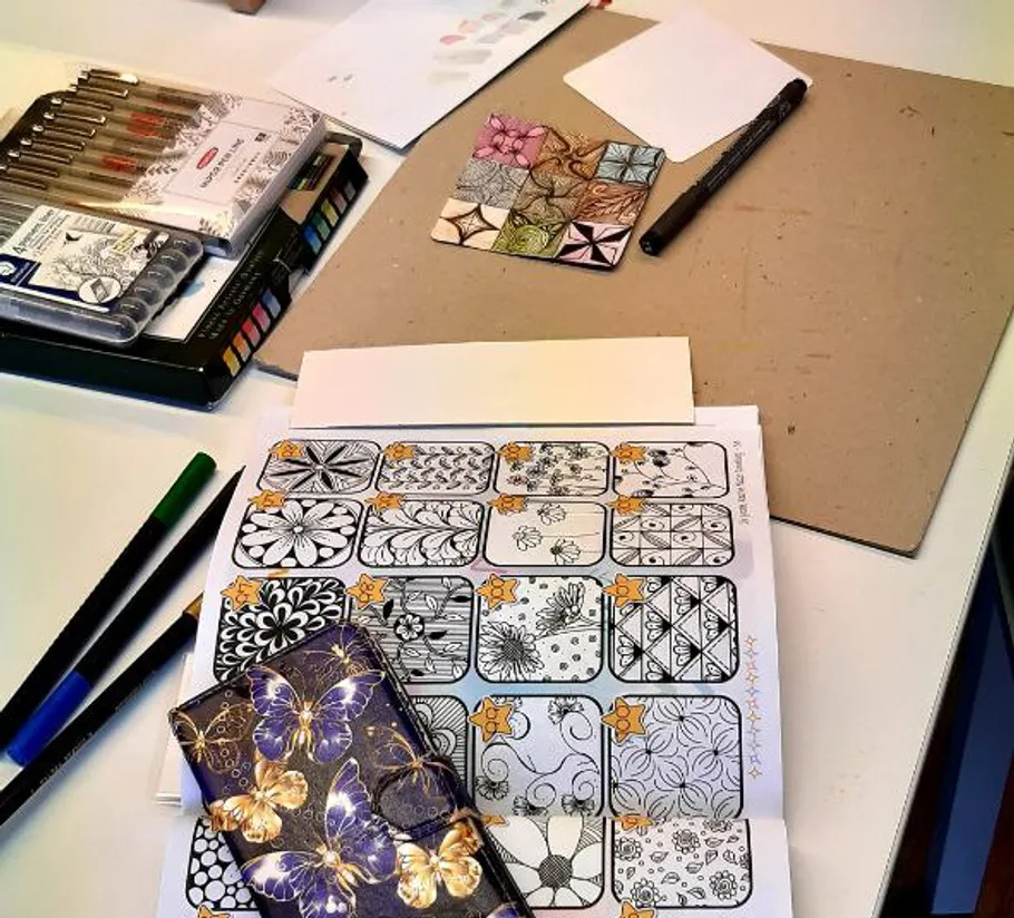 Art supplies and doodles on a desk.