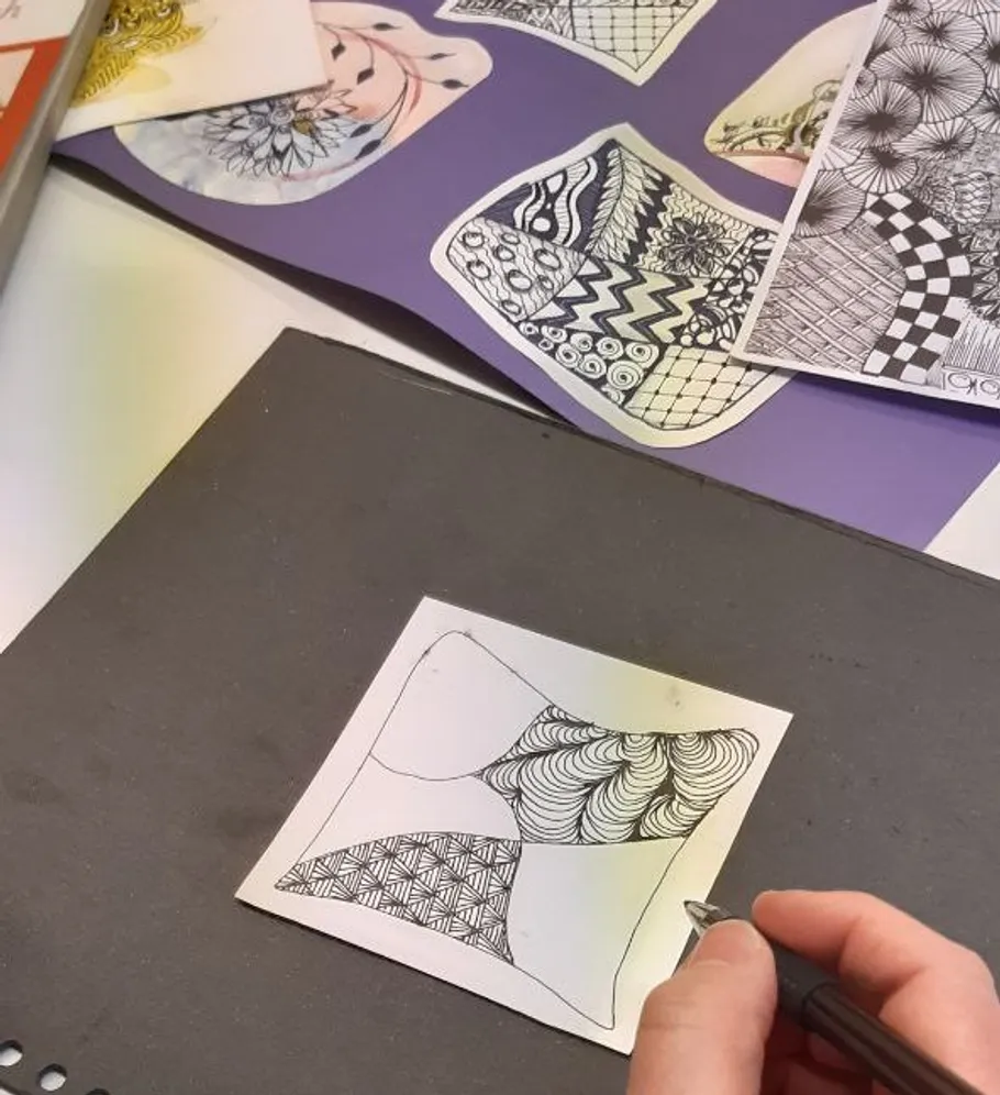 Hand drawing intricate patterns on paper.