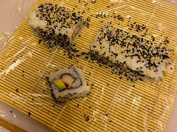 Sushi-Reststück liegt auf einem Bambusmatte, unvollständig.
