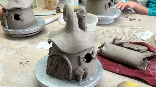 Clay fairy houses being handcrafted on a table.