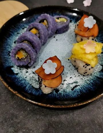 Colorful sushi rolls on decorative plate.