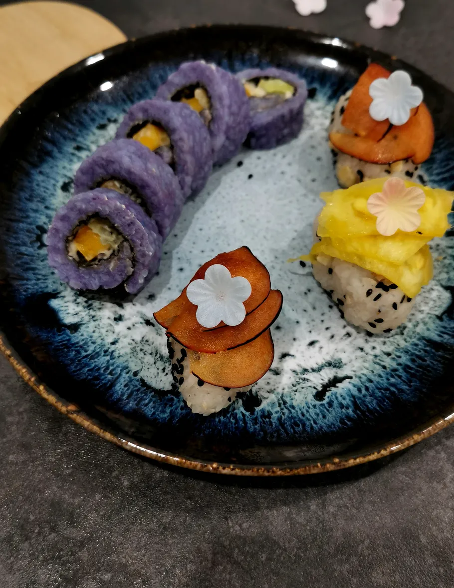 Bunte Sushi-Rollen auf dekorativem Teller.