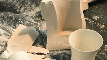 Sculptures and fragments on textured surface.