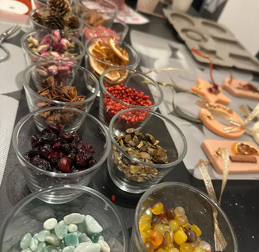 Glass cups with dried herbs and stones displayed.