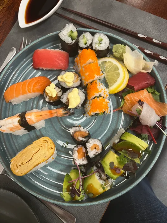 Verschiedene Sushi auf einem blauen Teller.