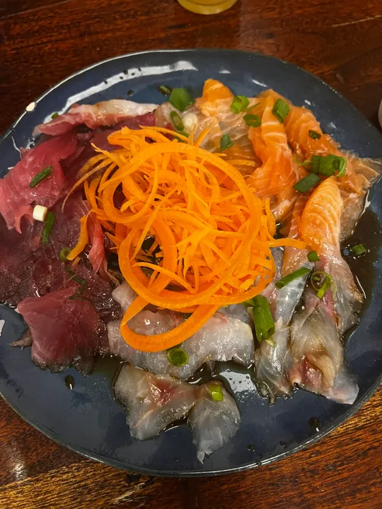 Assorti von Sashimi auf Teller mit Karotten.