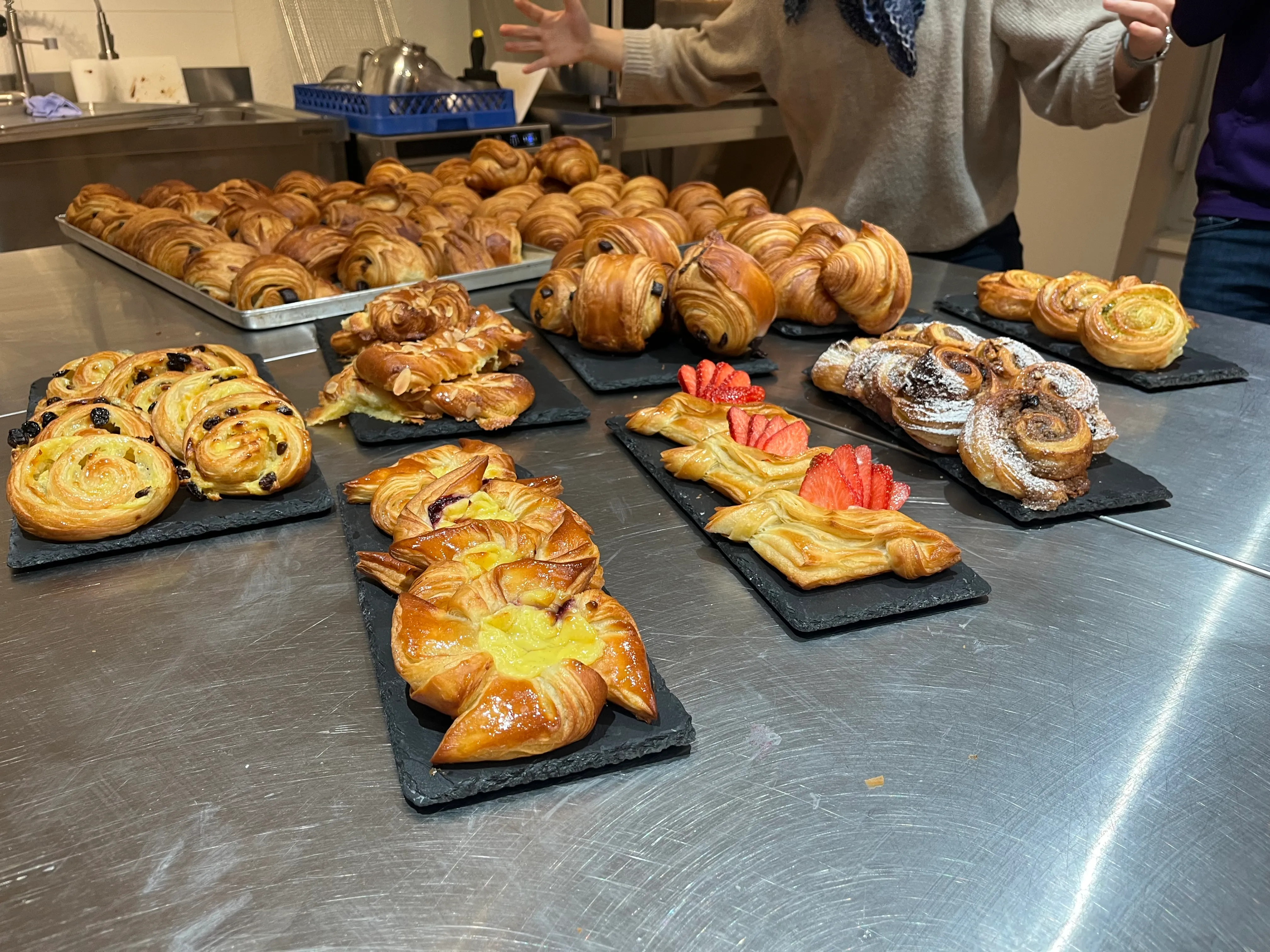 Verschiedene Gebäckstücke auf Tabletts in Küche.