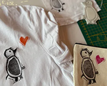Penguin-themed crafts with heart designs displayed.