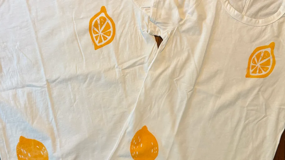 White t-shirts with orange lemon prints.