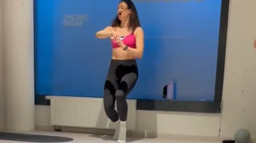 Woman exercising energetically in a fitness studio.