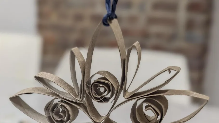 Paper ornament hanging indoors, blurred background.