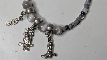 Perlenarmband mit Eulen-, Blatt-, Stiefel-Anhängern.