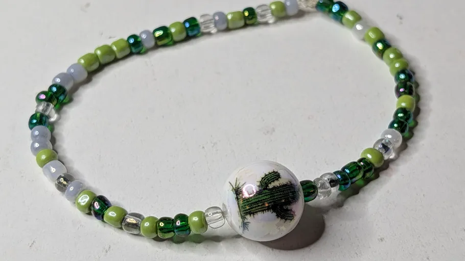 Perlenarmband mit Kakteen-Design-Mittelstück.