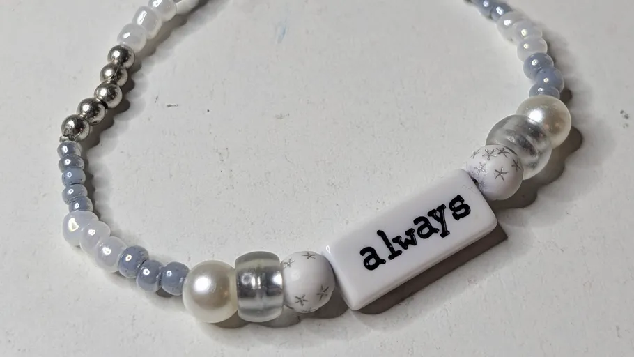 Perlenarmband mit 'always' auf weißem Hintergrund.