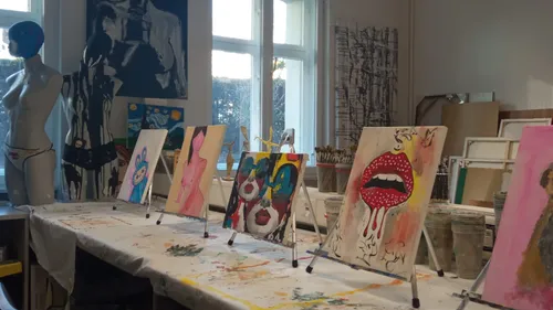 Kunststudio mit bunten Bildern auf Staffeleien.