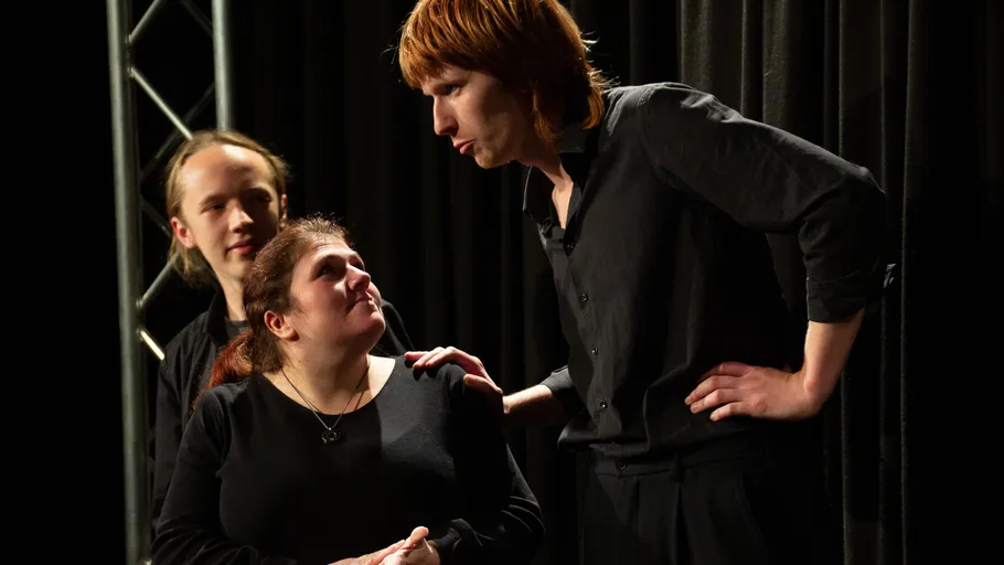 Drei Schauspieler spielen eine dramatische Szene.