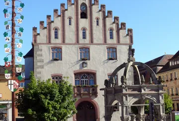 Traditionelles Gebäude mit dekorativer Fassade, Brunnen.