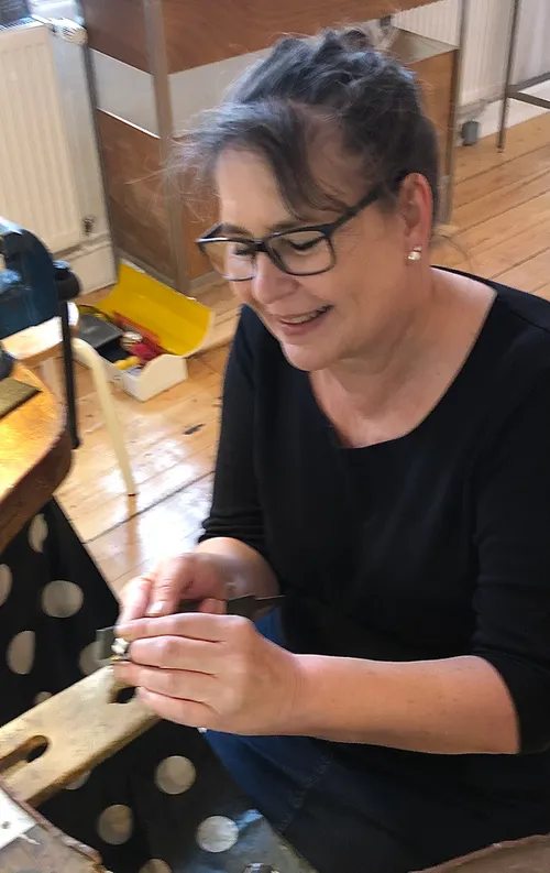 Woman crafting jewelry in a workshop.