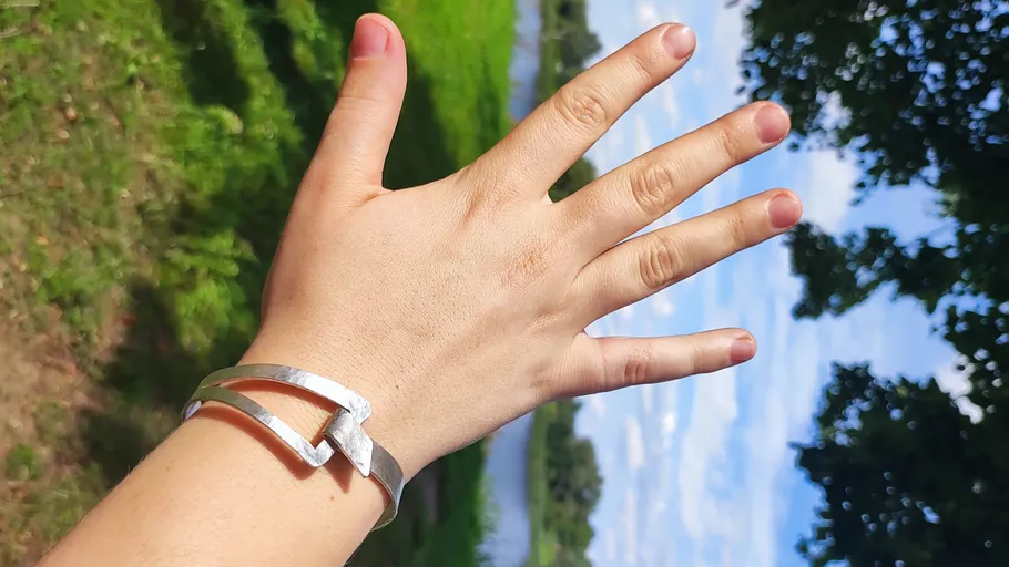 Hand wearing bracelet, nature background.