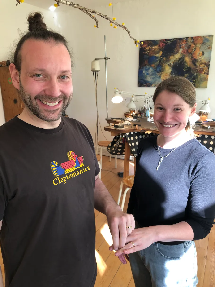 Lächelndes Paar tauscht Ringe im Zimmer.