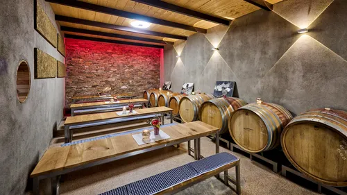 Wine barrels and benches in rustic cellar.