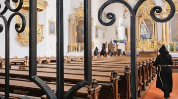 Mönche gehen im prunkvollen Kircheninneren.
