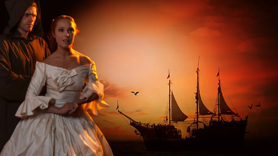 Man and woman with ship at sunset.