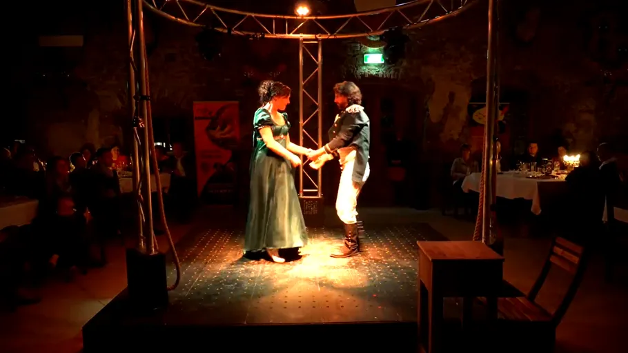 Couple dancing on a dimly lit stage.