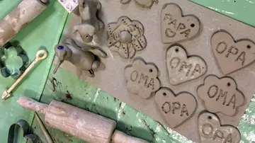 Clay crafts with tools on green table.