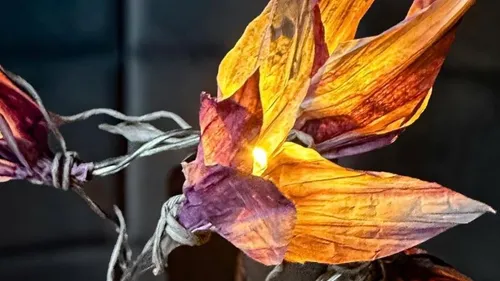 Illuminated decorative flower, glowing warmly in darkness.