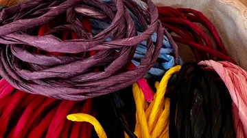 Colorful paper cords coiled in a basket.