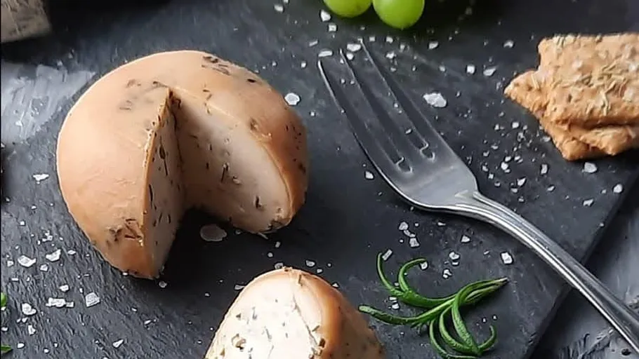 Käse-Rad mit Kräutern, Trauben, Crackern.