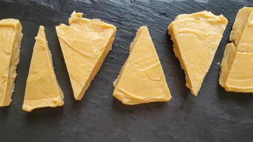 Triangular cheese pieces on dark slate surface.