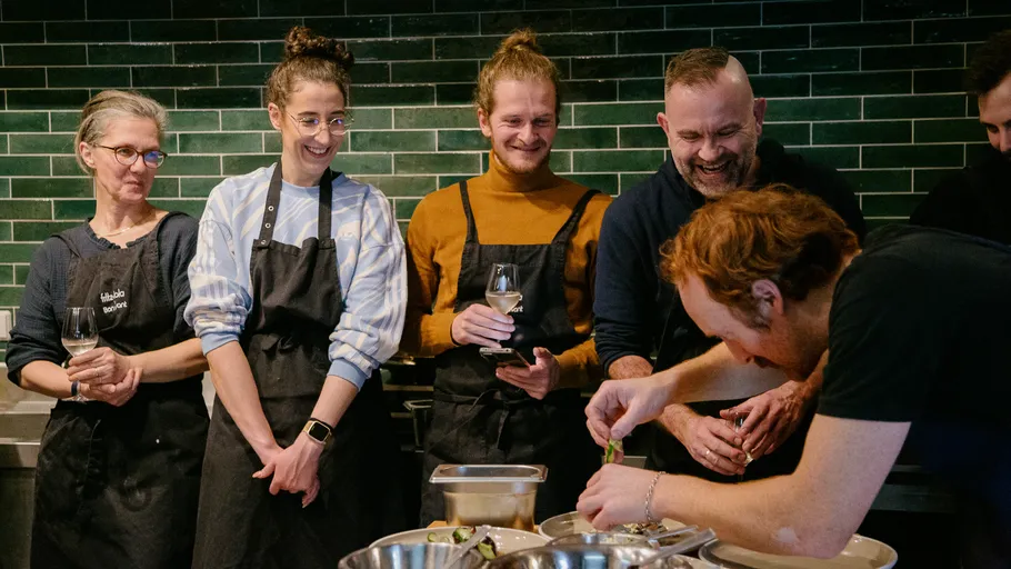 Gruppe beobachtet Koch bei Zubereitung im Küche.