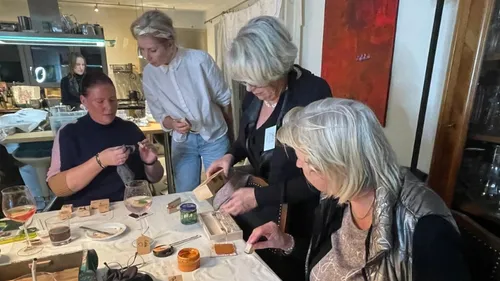 Gruppe fertigt Schmuck an einem Tisch.