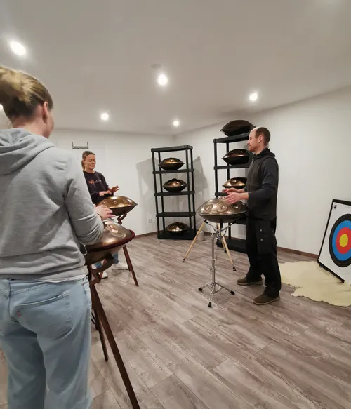 People playing hang drums in a room.